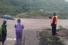 Các lực lượng chức năng xã Đakrông, Quảng Trị túc trực tại các ngầm tràn bị ngập. (Ảnh: TTXVN phát)