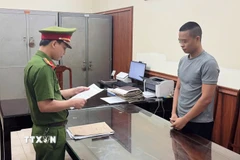 Cơ quan Cảnh sát điều tra công bố lệnh bắt tạm giam đối tượng Lê Văn Hải. (Ảnh: TTXVN phát)