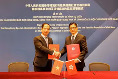 Phó Viện trưởng Viện Kiểm sát nhân dân tối cao Trần Hải Quân và Cục trưởng Cục An ninh Hong Kong Đặng Bính Cường ký kết hiệp định. (Ảnh: Xuân Vịnh/TTXVN)