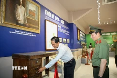 Bộ trưởng Công an Lương Tam Quang nghe thuyết trình tại Nhà trưng bày Khu di tích lịch sử quốc gia đặc biệt Căn cứ Trung ương Cục miền Nam. (Ảnh: Giang Phương/TTXVN)
