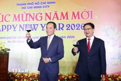 Ông Trần Lưu Quang (trái), Ủy viên Bộ Chính trị, Bí thư Thành ủy Thành phố Hồ Chí Minh mời quan khách nâng ly chúc mừng năm mới. (Ảnh: Xuân Khu/TTXVN)