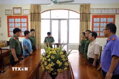 Cơ quan điều tra Công an tỉnh Lạng Sơn ra Lệnh giữ người trong trường hợp khẩn cấp đối với Lê Việt Hùng (áo xanh), để điều tra hành vi cưỡng đoạt tài sản. (Ảnh: TTXVN phát)