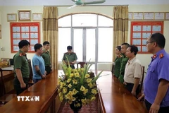 Cơ quan điều tra Công an tỉnh Lạng Sơn ra Lệnh giữ người trong trường hợp khẩn cấp đối với Lê Việt Hùng (áo xanh), để điều tra hành vi cưỡng đoạt tài sản. (Ảnh: TTXVN phát)