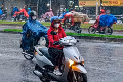 Mưa đột ngột sau một ngày nắng không gợn mây khiến nhiều người dân bất ngờ, không kịp chuẩn bị. (Ảnh: TTXVN phát)
