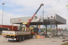 Máy móc, nhân lực thực hiện tháo dỡ trạm thu phí cầu Đồng Nai. (Ảnh: Công Phong/TTXVN)