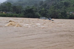 Chiếc xe container vượt ngầm tràn, tài xế bị lũ cuốn trôi mất tích. (Ảnh: TTXVN phát)