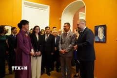 Phu nhân Ngô Phương Ly xem triển lãm. (Ảnh: Tâm Hằng/TTXVN)