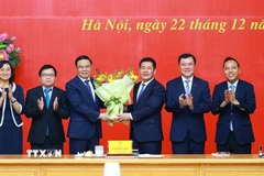 Đồng chí Nguyễn Hồng Diên, Ủy viên Trung ương Đảng, Phó Bí thư Chuyên trách Đảng uỷ Quốc hội tặng hoa chúc mừng đồng chí Lê Mạnh Hùng, Quyền Bộ trưởng Bộ Công Thương. (Ảnh: Dương Giang/TTXVN)