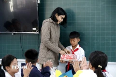 Cô giáo chủ nhiệm trao quà cho em Nguyễn Anh Tín, học sinh lớp 5D Trường tiểu học Lâm Hưng, bị thiệt hại nặng do mưa lũ. (Ảnh: Hồng Hiếu/TTXVN)