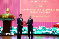 Đồng chí Lê Minh Hưng, Ủy viên Bộ Chính trị, Bí thư Trung ương Đảng, Trưởng Ban Tổ chức Trung ương trao Quyết định cho đồng chí Lê Ngọc Quang. (Ảnh: Anh Dũng/TTXVN)