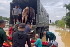 Do nhiều tuyến đường trong thôn An Lạc, xã Trung Giã (Hà Nội) đã ngập sâu, lực lượng chức năng dùng thuyền và ô tô chuyên dụng đưa người dân di tản an toàn. (Ảnh: TTXVN phát)