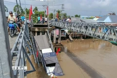 Xe tải chở gạo rơi xuống sông Thốt Nốt khi cầu 30/4 bị sập. (Ảnh: TTXVN phát)