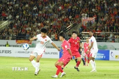 Pha xử lý bóng của cầu thủ đội tuyển Việt Nam trong vòng cấm địa đội tuyển Lào. (Ảnh: Đỗ Bá Thành/TTXVN)