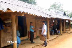 Cán bộ xã Phiêng Pằn (bên phải) tuyên truyền về chủ trương sắp xếp, tổ chức lại thôn, bản đến ông Thào A Mua, dân tộc Mông ở bản Kéo Lồm, sau sắp xếp sẽ thuộc bản Kết Hay. (Ảnh: Quang Quyết/TTXVN)