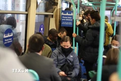 Người dân đi xe buýt tại London, Anh trong thời gian diễn ra đại dịch COVID-19. (Ảnh: THX/TTXVN)