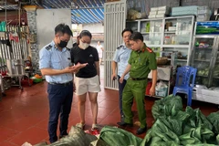 Lực lượng chức năng tiến hành kiểm tra phát hiện và thu giữ 9400 sản phẩm xúc xích lạp xưởng không rõ nguồn gốc. (Ảnh: TTXVN phát)