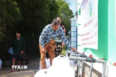 Người dân xã Vĩnh Châu nhận nước sạch miễn phí. (Ảnh: Thu Hiền/TTXVN)