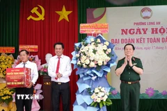 Đại tướng Nguyễn Trọng Nghĩa trao quà cho khu phố Phú Nhơn, phường Long An, tỉnh Tây Ninh. (Ảnh: Đức Hạnh/TTXVN)