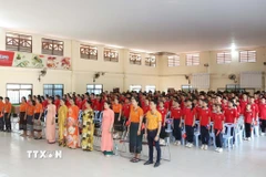 Thầy trò Trường song ngữ Lào-Việt Nam Nguyễn Du thực hiện nghi thức Chào cờ trước giờ xem truyền hình trực tiếp Lễ kỷ niệm 50 năm Giải phóng miền Nam, thống nhất đất nước.(Ảnh: Xuân Tú/TTXVN)