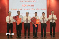 Thường trực Tỉnh ủy Khánh Hòa trao quyết định và tặng hoa chúc mừng ông Tạ Hồng Quang (bên trái) và nhà báo Lê Hoàng Triều (bên phải). (Ảnh: Xuân Triệu/TTXVN)