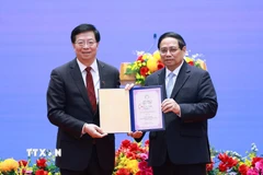 Ông Khưu Dũng, Bí thư Đảng ủy Đại học Thanh Hoa, Trung Quốc trao tặng Thủ tướng Phạm Minh Chính danh hiệu "Giáo sư danh dự Đại học Thanh Hoa." (Ảnh: Dương Giang/TTXVN)