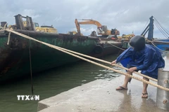 Người dân Huế đưa thuyền vào vị trí an toàn. (Ảnh: Văn Dũng/TTXVN)