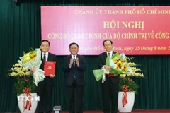 Thường trực Ban Bí thư Trần Cẩm Tú trao các quyết định của Bộ Chính trị cho đồng chí Nguyễn Văn Nên và đồng chí Trần Lưu Quang. (Ảnh: Tiến Lực/TTXVN)