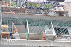 Một hộ dân cư xá Thanh Đa thuê thợ sắt tháo dỡ “chuồng cọp” ở ban công. (Ảnh: Linh Sơn/TTXVN)