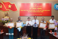 Ông Huỳnh Quốc Việt, Phó Bí thư thường trực Tỉnh ủy và bà Lê Thị Nhung, Phó Chủ tịch Thường trực Hội đồng Nhân dân tỉnh Cà Mau trân trọng trao tặng Danh hiệu vinh dự Nhà nước "Bà mẹ Việt Nam Anh hùng" cho thân nhân 4 Bà mẹ Việt Nam Anh hùng được Chủ tịch nước truy tặng. (Ảnh: Chanh Đa/TTXVN)
