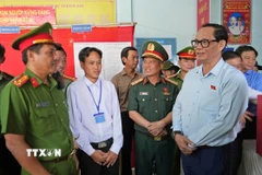 Phó Chủ tịch Quốc hội Trần Quang Phương (bên phải) kiểm tra công tác bầu cử tại điểm bỏ phiếu số 1 (ấp Kênh Đào, xã Đất Mũi). (Ảnh: Huỳnh Anh/TTXVN)