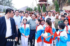 Thủ tướng Phạm Minh Chính với học sinh tỉnh Điện Biên dự Lễ khánh thành công trình bảo tồn, tôn tạo di tích Khu trung tâm đề kháng Him Lam (giai đoạn II). (Ảnh: Dương Giang/TTXVN)