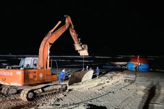 Xe máy xúc vận chuyển những tấm thép lớn để làm đường cho xe cần cẩu hạng nặng tiếp hiện trường tàu gặp nạn. (Ảnh: Nguyên Linh/TTXVN)