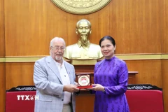 Phó Chủ tịch Ủy ban Trung ương Mặt trận Tổ quốc Việt Nam Hà Thị Nga trao quà tặng Bí thư Đảng Cộng sản Anh Robert Griffiths. (Ảnh: TTXVN phát)