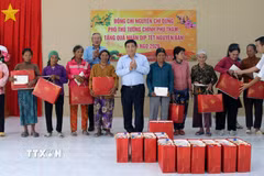 Phó Thủ tướng Chính phủ Nguyễn Chí Dũng tặng quà Tết cho đồng bào Raglai tại xã Anh Dũng. (Ảnh: Công Thử/TTXVN)