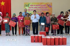 Phó Thủ tướng Chính phủ Nguyễn Chí Dũng tặng quà Tết cho đồng bào Raglai tại xã Anh Dũng. (Ảnh: Công Thử/TTXVN)