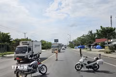 Lực lượng Cảnh sát giao thông hai tỉnh Vĩnh Long và Đồng Tháp phối hợp chặn dòng phương tiện để cầu Rạch Miễu trở thành đường 1 chiều trong khoảng 30 phút mỗi đợt để ưu tiên chiều còn lại. (Ảnh: Chương Đài/TTXVN)