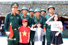 Các em thiếu nhi chụp ảnh lưu niệm với các chiến sỹ Đội pháo lễ, Lữ đoàn 96, Binh chủng pháo binh sau giờ luyện tập bắn đại bác tại công viên Bến Bạch Đằng, Quận 1, Thành phố Hồ Chí Minh. (Ảnh: Thanh Vũ/TTXVN)