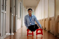 Gần 20 năm, thầy giáo Nguyễn Khả Tuyến “đi bằng đôi tay” đến trường dạy học. (Ảnh: Hoàng Hùng/TTXVN)