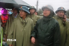 Phó Thủ tướng Hồ Quốc Dũng (thứ 2, phải) kiểm tra công tác ứng phó mưa lũ tại Khánh Hòa, yêu cầu di dời người dân đến nơi an toàn. (Ảnh: Đặng Tuấn/TTXVN)
