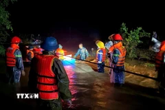 Lực lượng chức năng xã Yang Mao di dời các hộ dân vùng ngập lụt đên nơi an toàn trong đêm. (Ảnh: TTXVN phát)