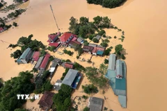 Các vùng lũ bị cô lập được trực thăng thả hàng cứu trợ. (Ảnh: TTXVN phát)