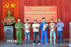 Cơ quan chức năng tặng hoa xin lỗi người bị hàm oan. (Ảnh: TTXVN phát)