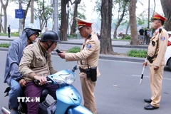 Trong sáng mùng 1 Tết, Đội Cảnh sát giao thông số 1, Công an Hà Nội đã bố trí nhiều tổ công tác trên các tuyến phụ trách, tập trung xử lý vi phạm nồng độ cồn với người điều khiển ô tô, xe máy và xe đạp. (Ảnh: Phạm Kiên/TTXVN)
