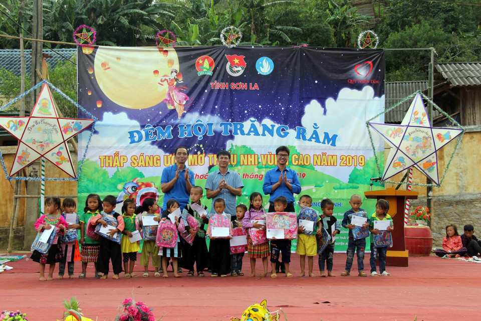 Ban tổ chức trao tặng quà cho học sinh có hoàn cảnh khó khăn.(Ảnh: Diệp Anh/TTXVN)