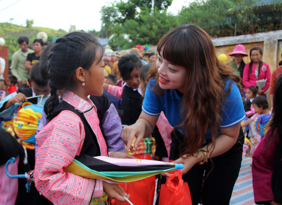 Ban tổ chức trao tặng quà cho học sinh có hoàn cảnh khó khăn.(Ảnh: Diệp Anh/TTXVN)