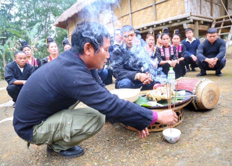 Thầy cúng và gia chủ thực hiện nghi lễ cúng thần đất và ma bản dưới sân nhà để xin các vị thần linh, thổ địa phù hộ cho gia đình cùng dân bản. (Ảnh: Tuấn Đức/TTXVN)