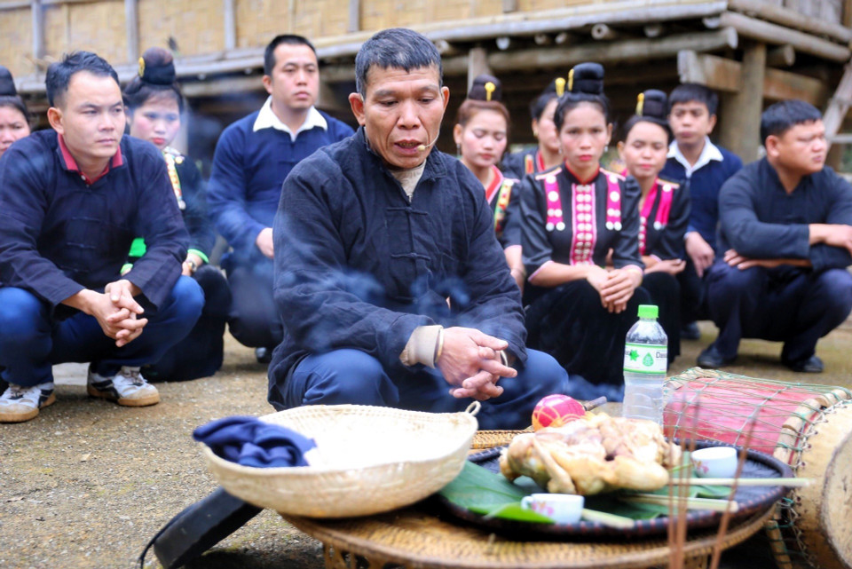 Thầy cúng thực hiện nghi lễ cúng thần đất và ma bản dưới sân nhà để xin các vị thần linh, thổ địa phù hộ cho gia đình cùng dân bản. (Ảnh: Tuấn Đức/TTXVN)