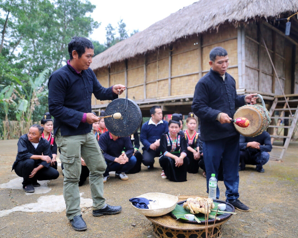Thầy cúng và gia chủ gõ hồi chiêng, hồi trống đánh thức thần đất dậy và mời ma bản về dự. (Ảnh: Tuấn Đức/TTXVN)