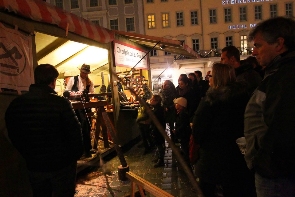  Du khách tận mắt chứng kiến cách thức làm đồ thủ công truyền thống tại chợ Giáng sinh Dresden. (Ảnh: Quang Hải/TTXVN)