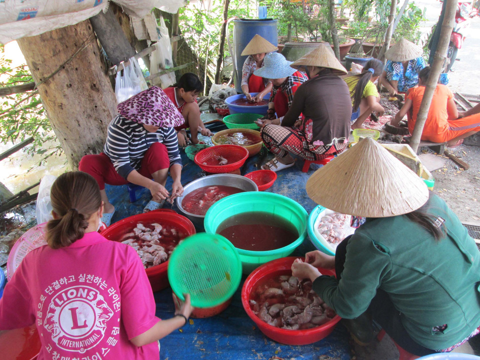 Các chủ sạp và nhân công đang tất bật làm thịt chuột để kịp giao cho khách. (Ảnh: Công Mạo/TTXVN)